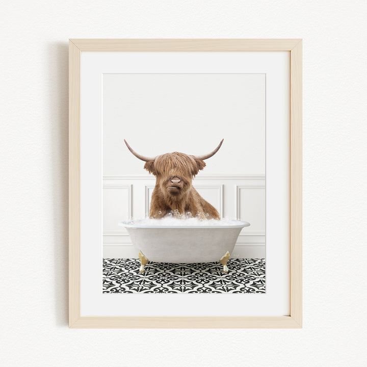 A Highland cow with long horns is sitting in a white bathtub filled with water, creating a whimsical and playful scene.