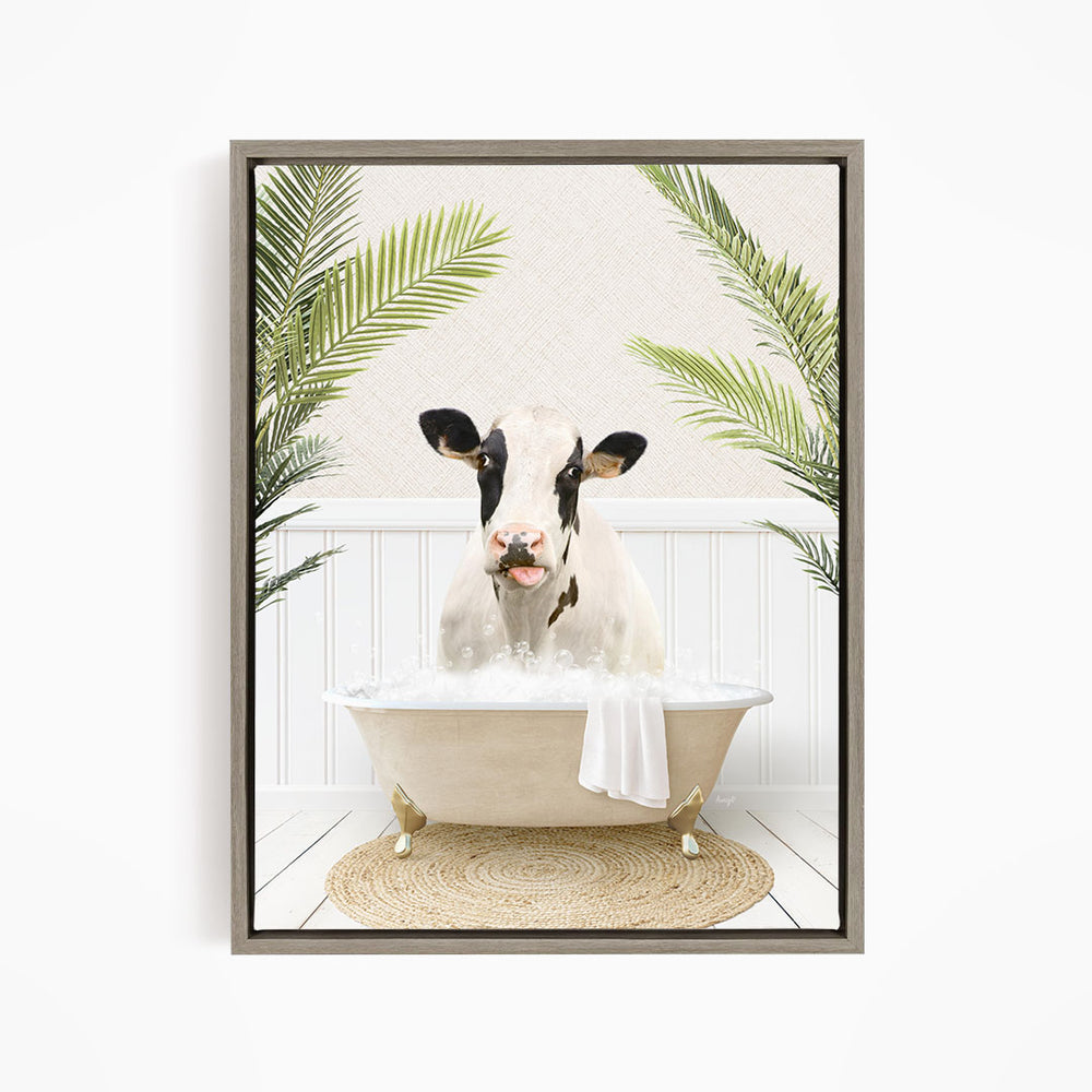 A black and white cow is sitting in a white bathtub filled with water, surrounded by green palm leaves.