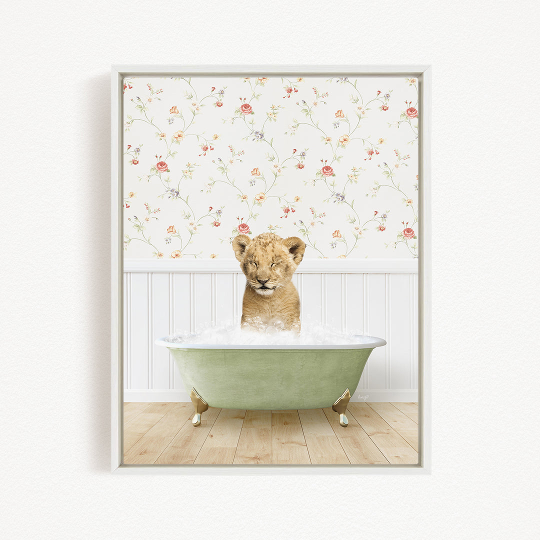 A young lion cub is sitting in a green bathtub filled with water, surrounded by a floral wallpaper.