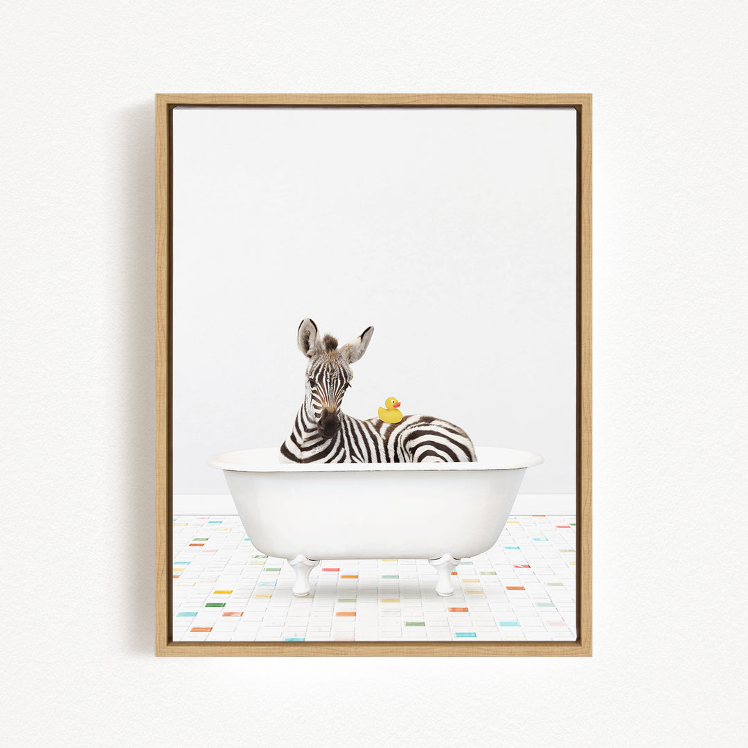 A zebra is sitting in a white bathtub, surrounded by a yellow rubber duck.