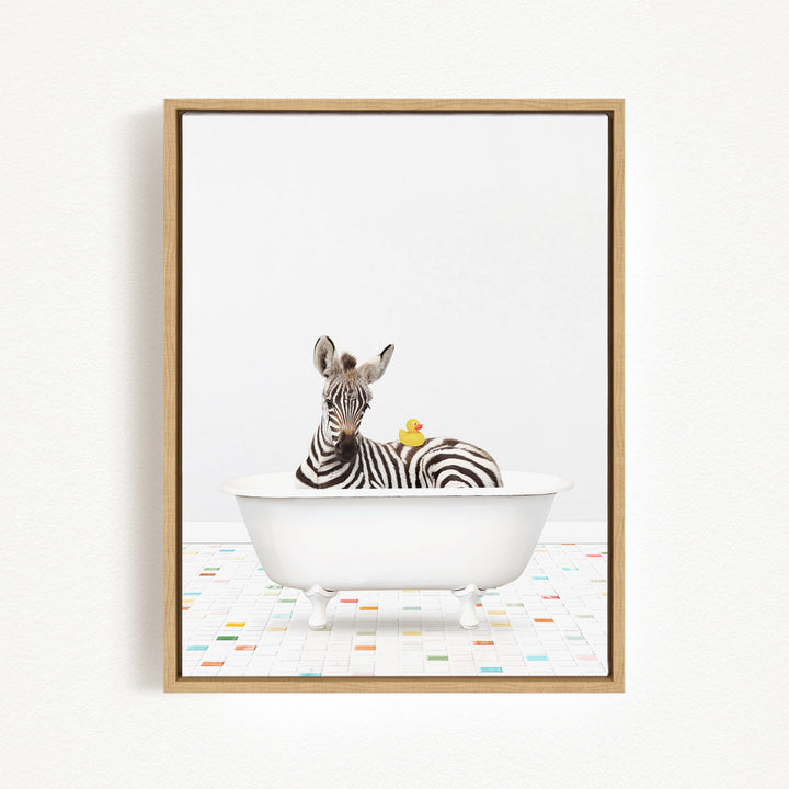 A zebra is sitting in a white bathtub, surrounded by a yellow rubber duck.