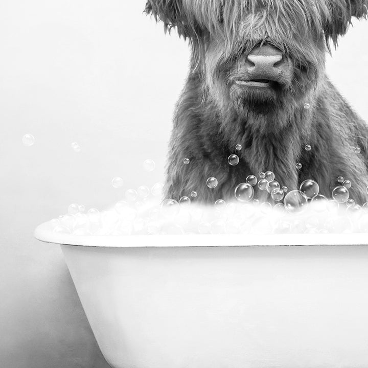 a black and white photo of a dog in a bathtub