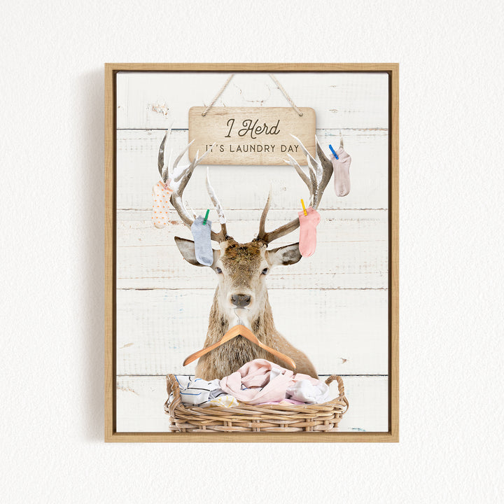 A deer with antlers is sitting in a wicker basket, with a sign above it that says "I herd it's laundry day".
