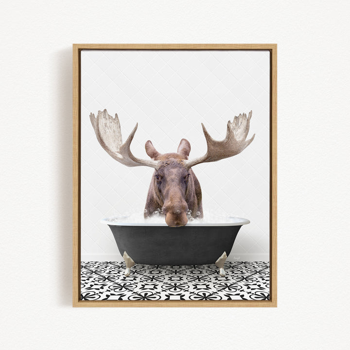 A moose with large antlers is sitting in a bathtub filled with water, creating a whimsical and humorous scene.