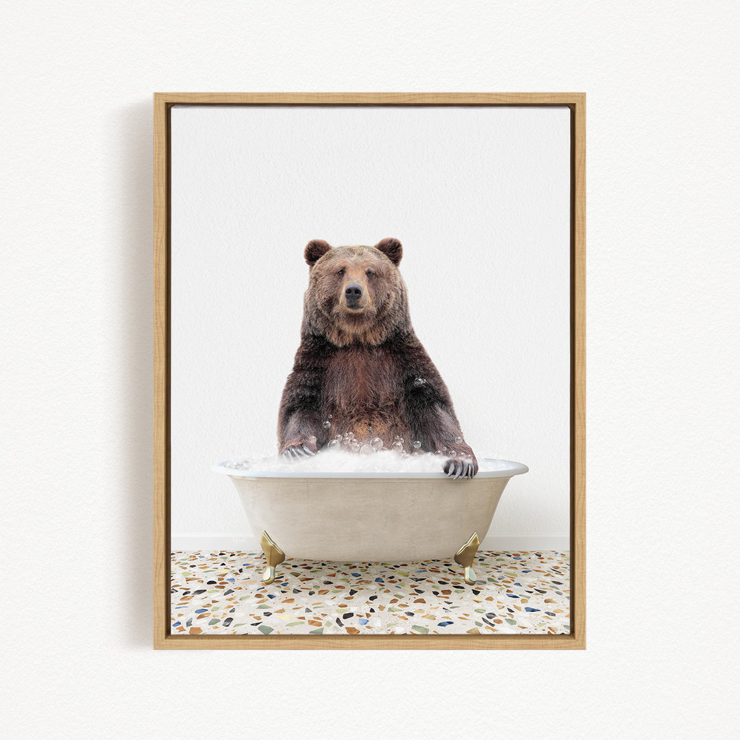 A brown bear sitting in a white bathtub filled with water, with its paws submerged in the water.