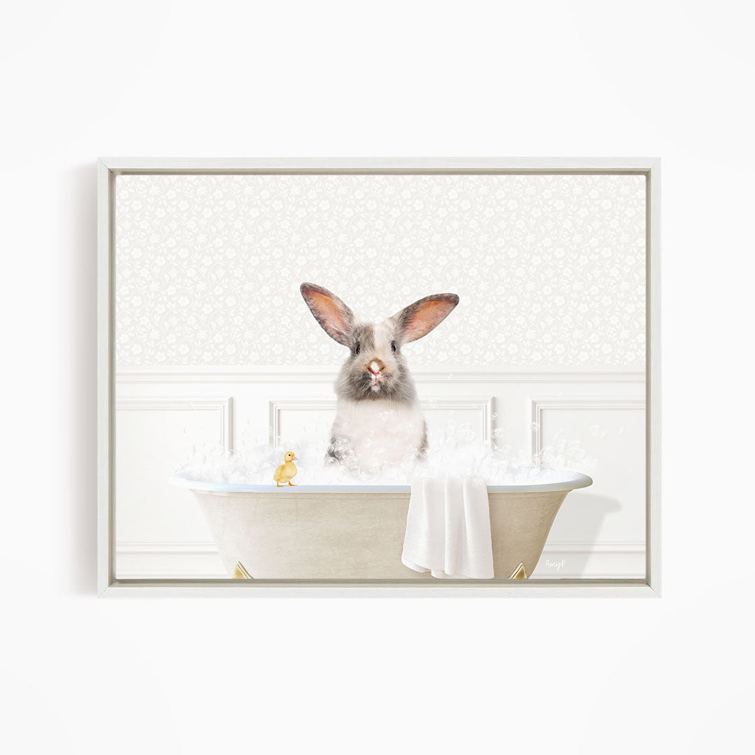 A fluffy white rabbit sits in a bathtub filled with bubbles, accompanied by a yellow duck.