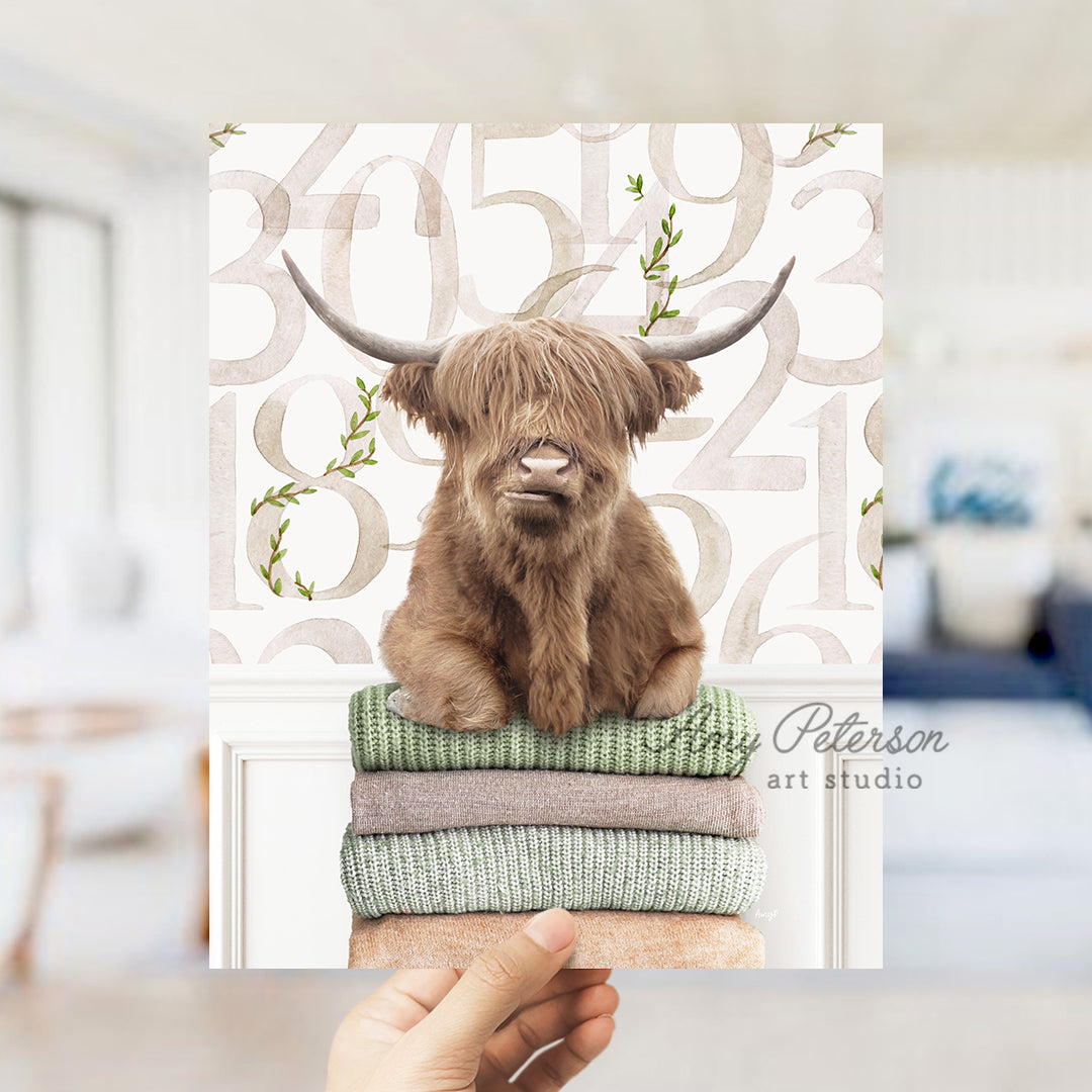 a hand holding up a card with a picture of a highland cow on it