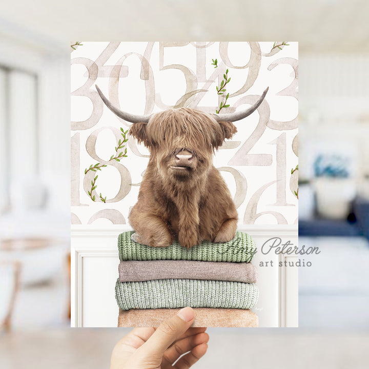 a hand holding up a card with a picture of a highland cow on it