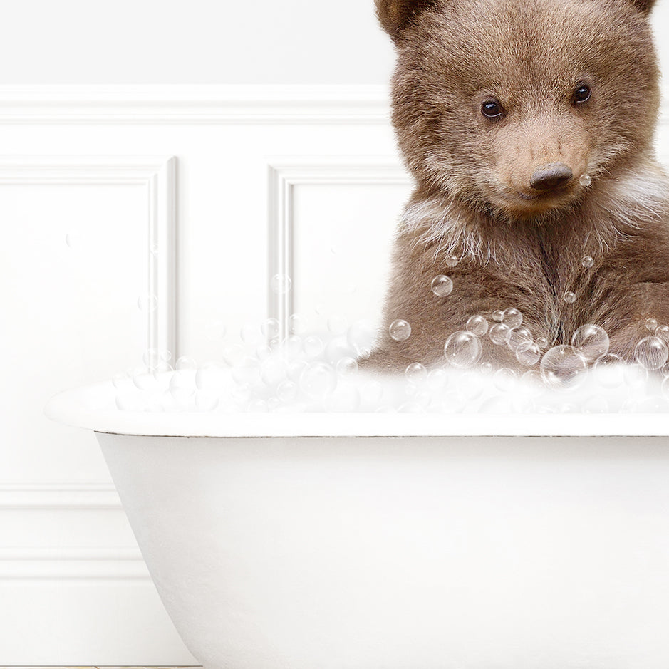 a brown bear sitting in a bath tub filled with bubbles