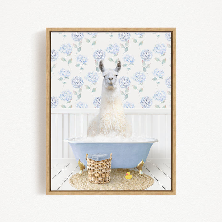 A white llama sitting in a blue bathtub filled with water, surrounded by a wicker basket and rubber ducks.