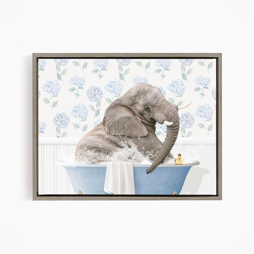 A gray elephant is sitting in a blue bathtub filled with water, surrounded by a floral pattern on the walls.