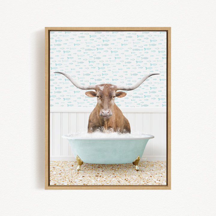 A brown steer with large horns is sitting in a light blue bathtub filled with bubbles, against a background of fish.