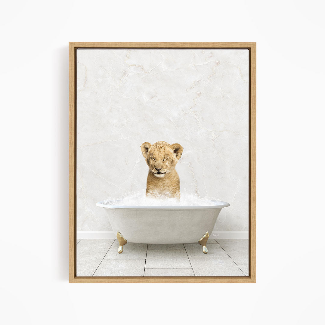 A young lion cub sitting in a white bathtub filled with water, looking directly at the camera.