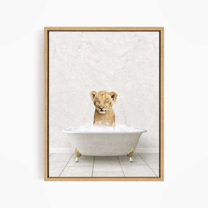 A young lion cub sitting in a white bathtub filled with water, looking directly at the camera.