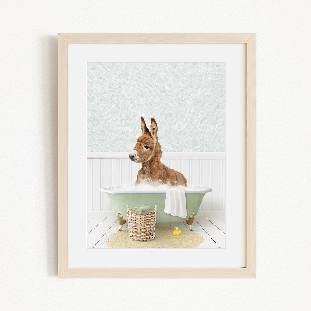 A donkey is sitting in a green bathtub filled with bubbles, surrounded by rubber ducks and a basket.