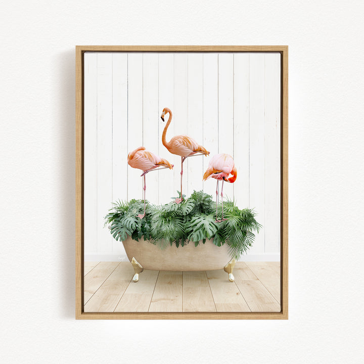 A framed image depicting three flamingos standing in a bathtub filled with green plants.