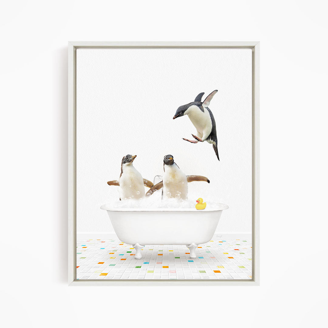 A framed image depicting three penguins enjoying a bath in a white bathtub, with one penguin flying above the tub.