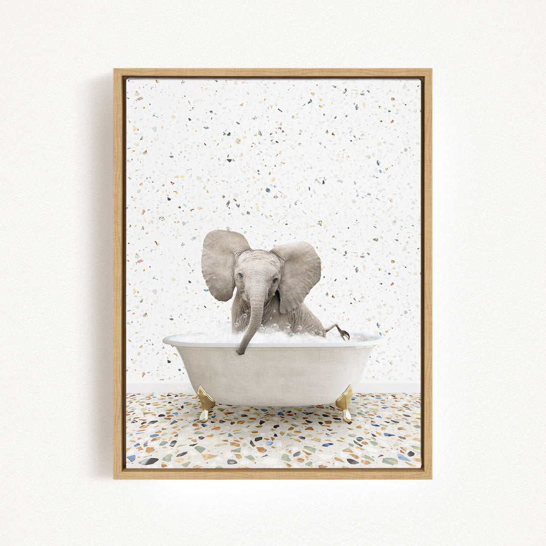 A baby elephant sitting in a white bathtub filled with water, surrounded by a speckled tiled floor.
