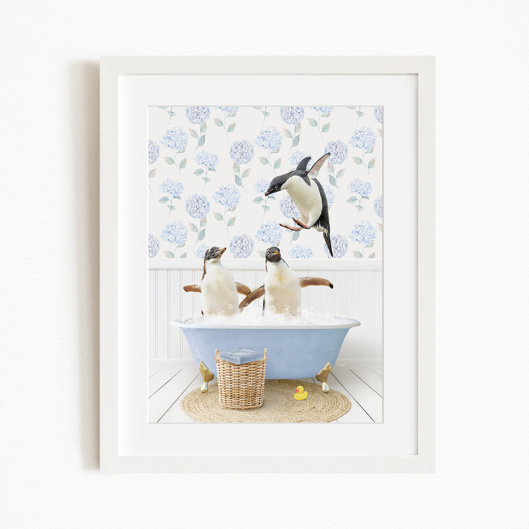 A framed image depicting two penguins sitting in a bathtub filled with bubbles, with one penguin standing on its hind legs and another sitting on its belly.