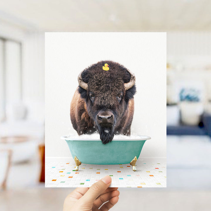 A buffalo with a yellow rubber duck sitting in a green bathtub.