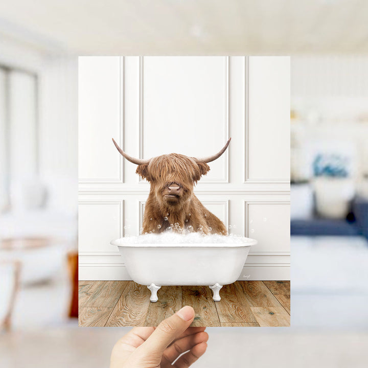 A brown Highland cow with long horns is sitting in a white bathtub filled with water, creating a whimsical and playful scene.