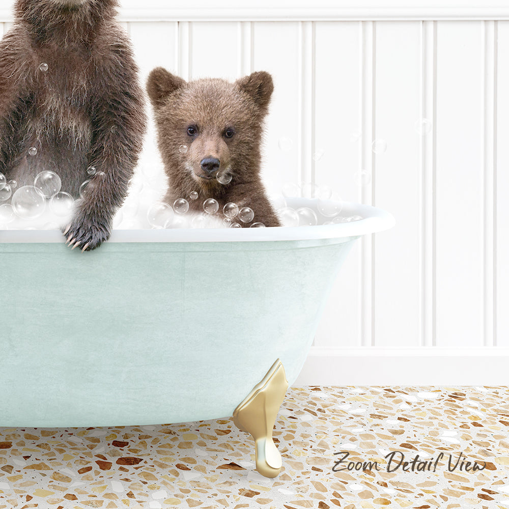 A baby bear sitting in a bathtub filled with bubbles, with another bear sitting next to it.
