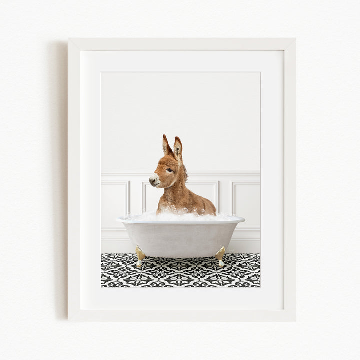 A donkey is sitting in a white bathtub filled with bubbles, creating a whimsical and playful scene.