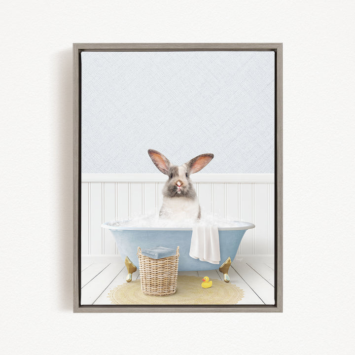 A white rabbit sitting in a blue bathtub filled with water, surrounded by a yellow rubber duck and a wicker basket.
