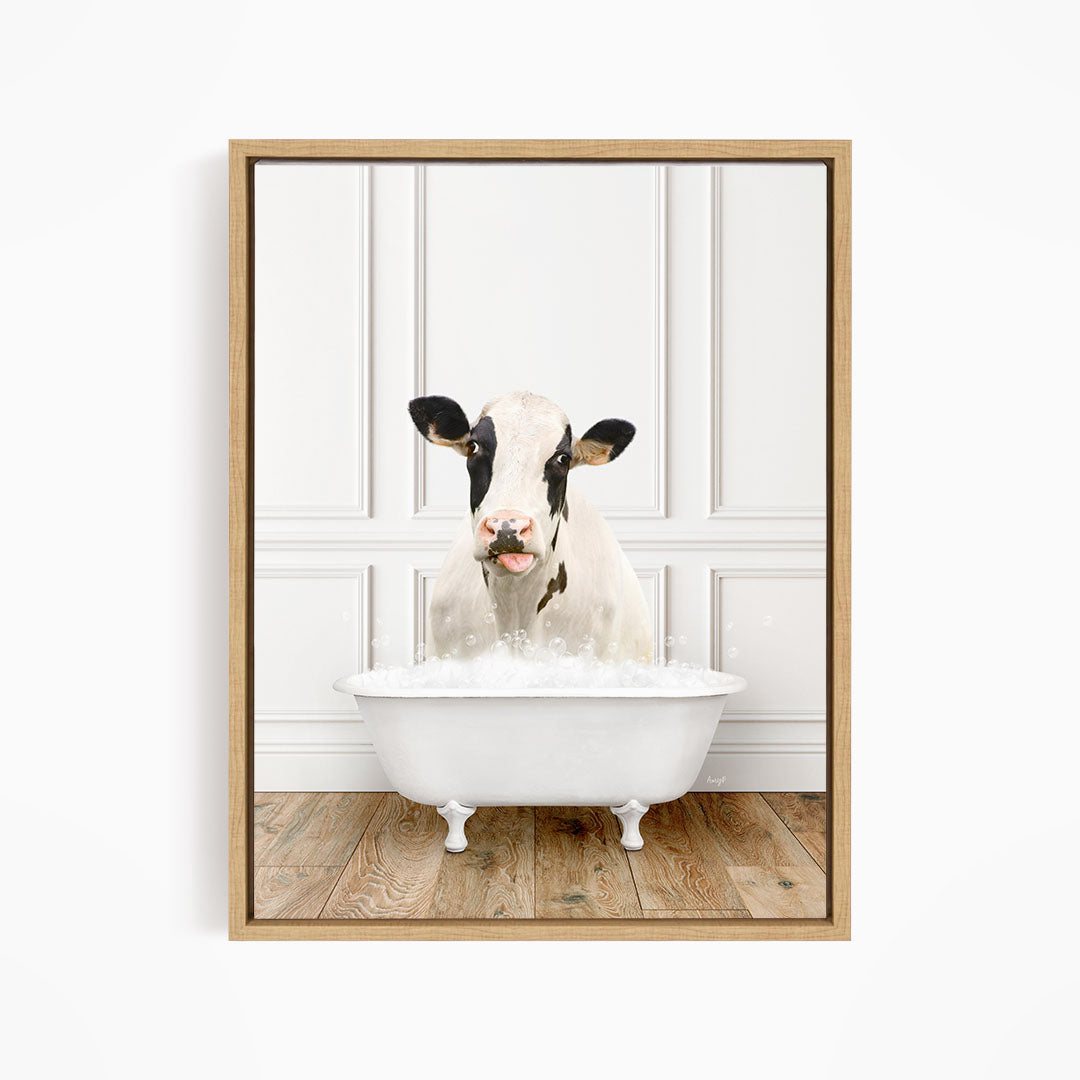 A black and white cow is sitting in a white bathtub filled with water, creating a whimsical and humorous scene.