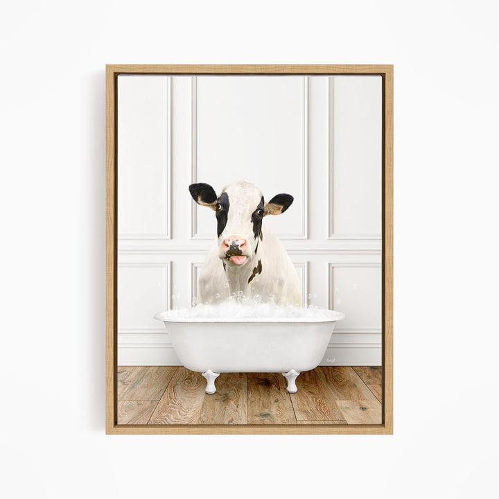 A black and white cow is sitting in a white bathtub filled with water, creating a whimsical and humorous scene.