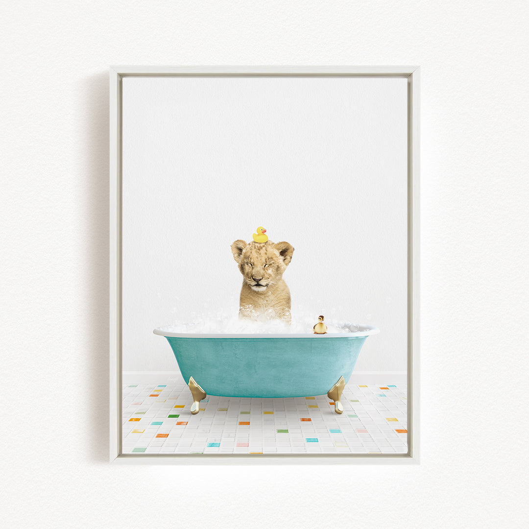 A young lion cub is sitting in a blue bathtub filled with bubbles, surrounded by rubber ducks.