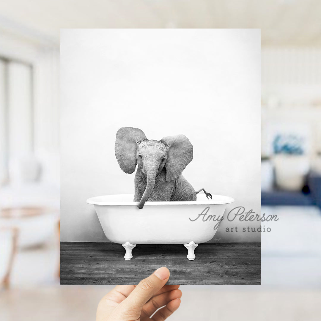 a person holding up a card with an elephant in a bathtub