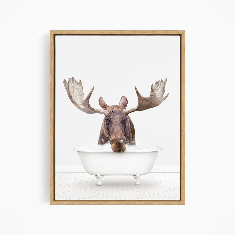 A moose with large antlers is sitting in a white bathtub filled with water, creating a whimsical and humorous scene.