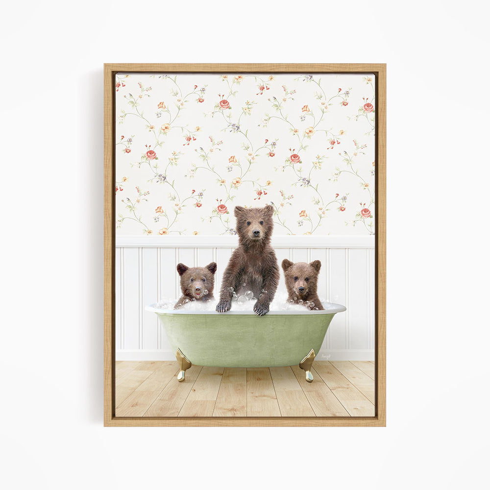 A framed image depicting three bears sitting in a green bathtub, with a floral wallpaper in the background.