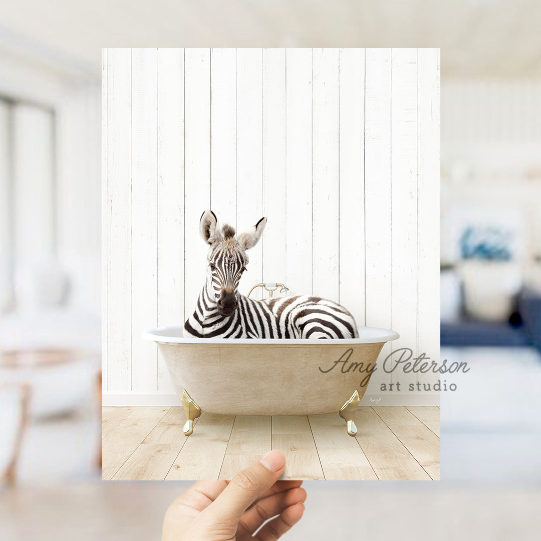 a hand holding a photo of a zebra in a bathtub