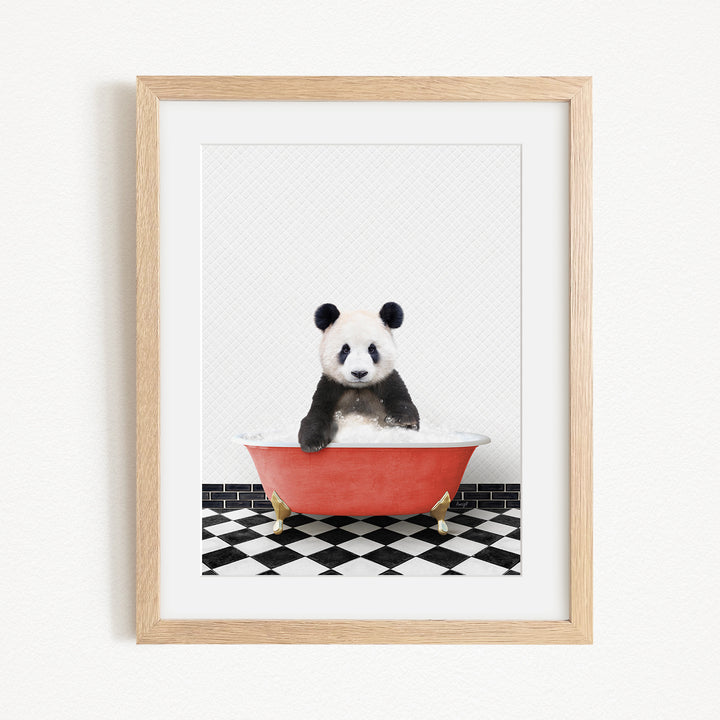 A panda bear sitting in a red bathtub on a black and white checkered floor.