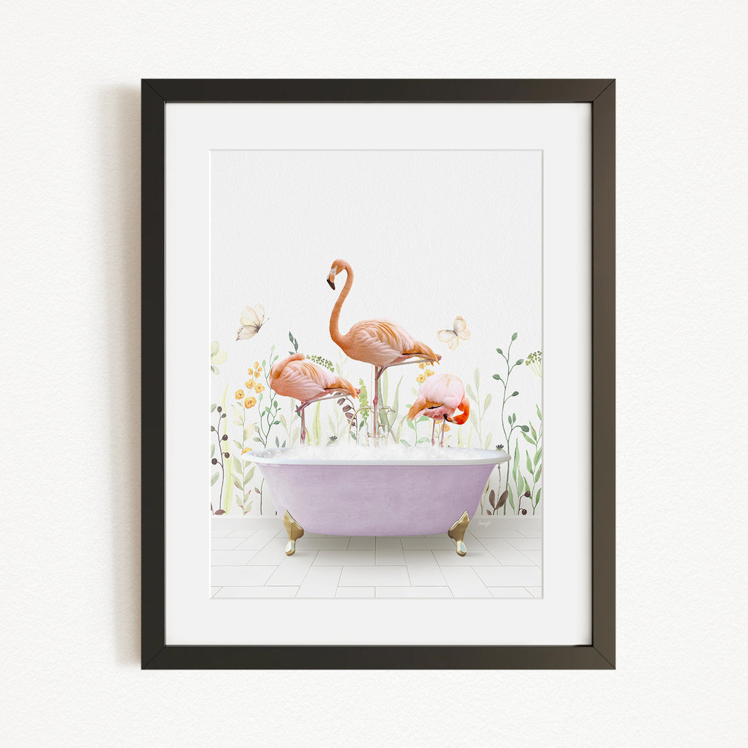 A framed illustration depicting three flamingos standing in a bathtub filled with bubbles, surrounded by a garden-like setting with flowers and butterflies.