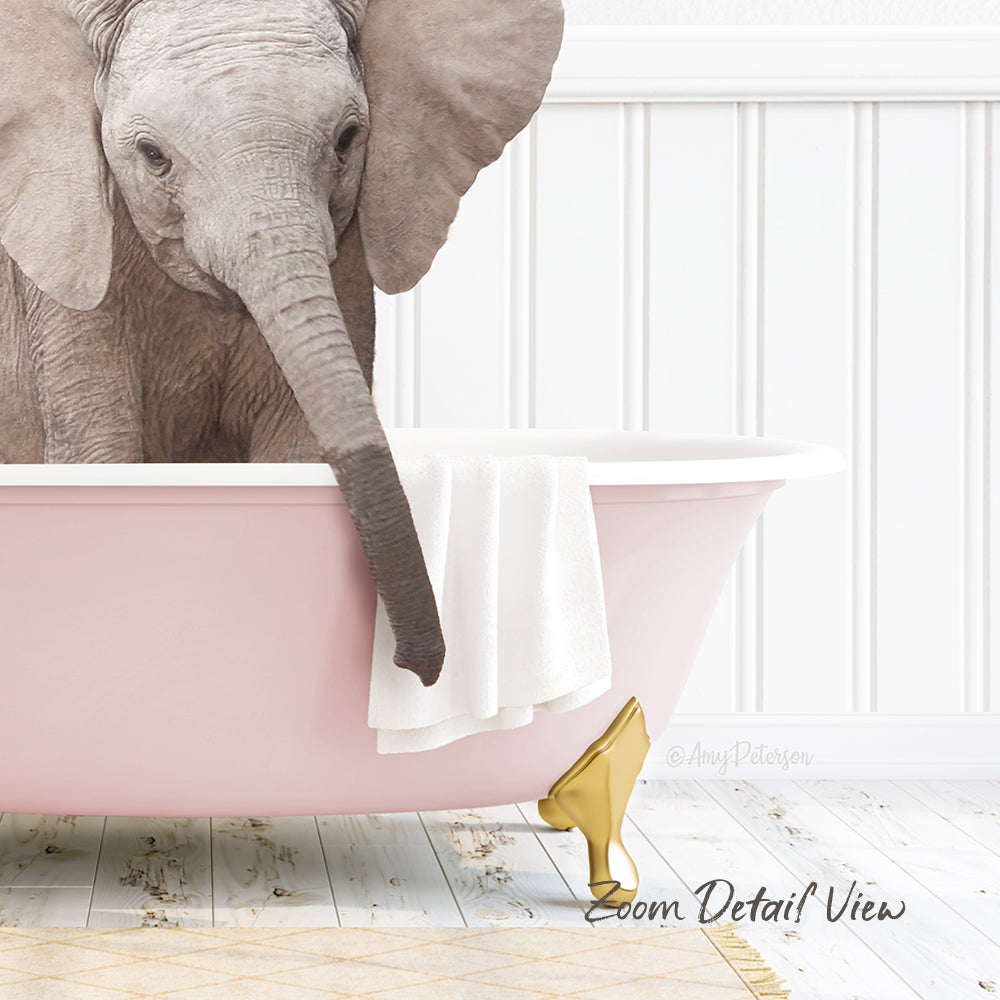 A baby elephant is sitting in a pink bathtub, with a towel and gold object nearby.