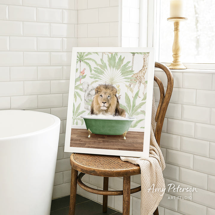 A framed painting of a lion sitting in a green bathtub, surrounded by tropical foliage, is displayed on a wooden chair in a bathroom setting.