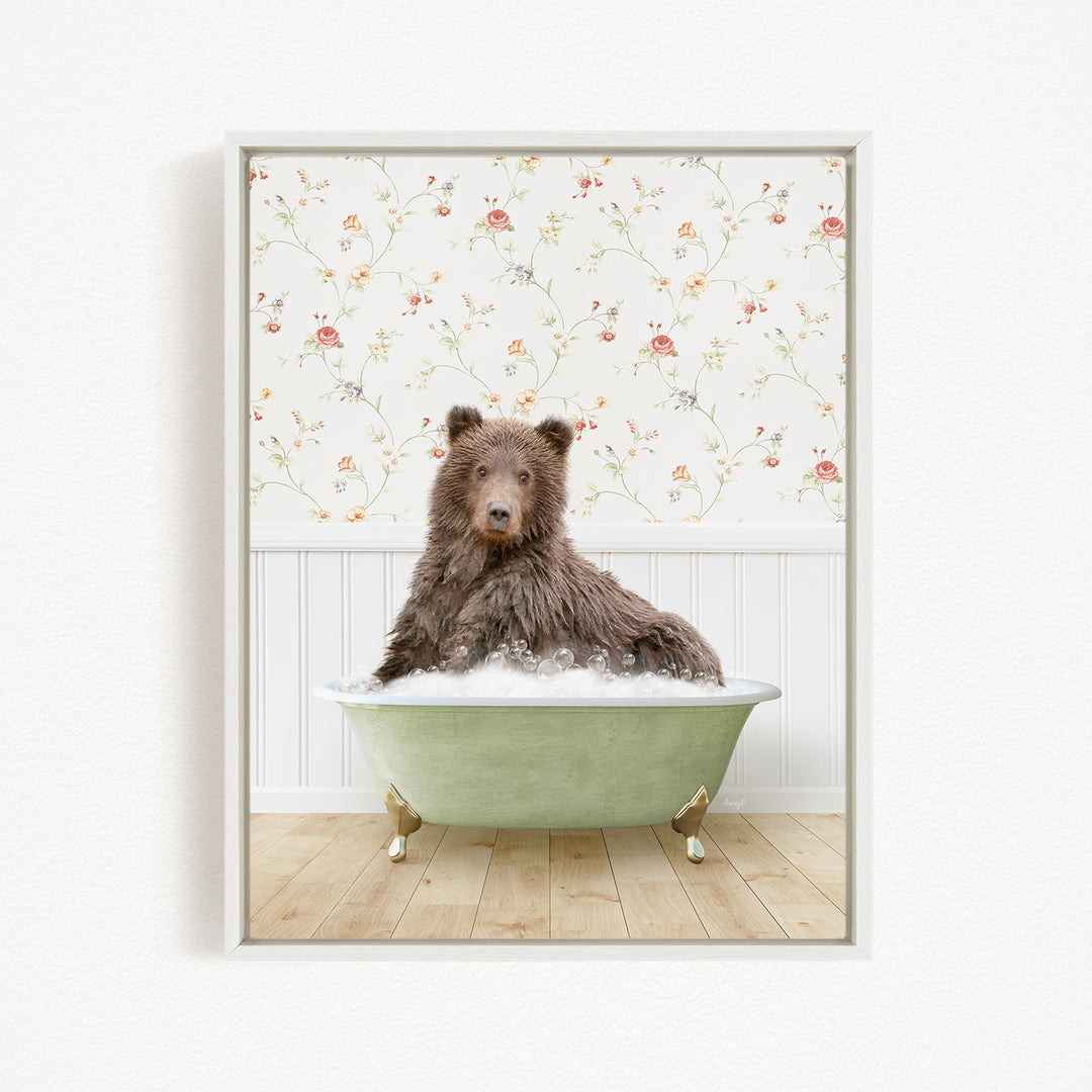 A brown bear sitting in a green bathtub filled with bubbles, with a floral wallpaper in the background.