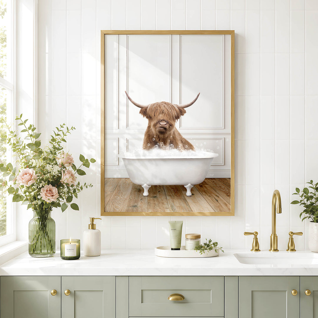 a bathroom with a framed photo of a Highland cow taking a bath in a white bathtub, surrounded by flowers and candles.