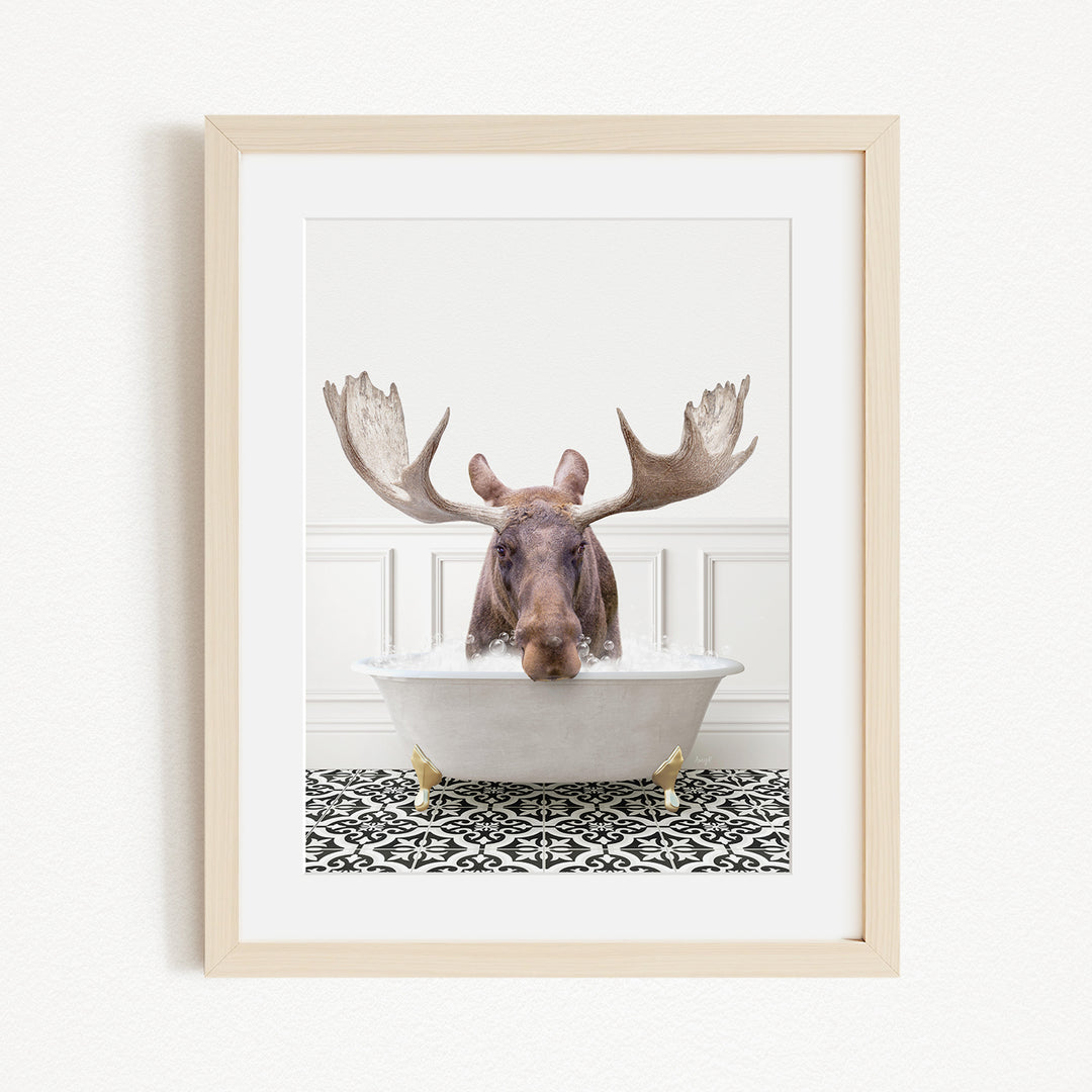 A moose with large antlers is sitting in a bathtub filled with water, creating a whimsical and humorous scene.