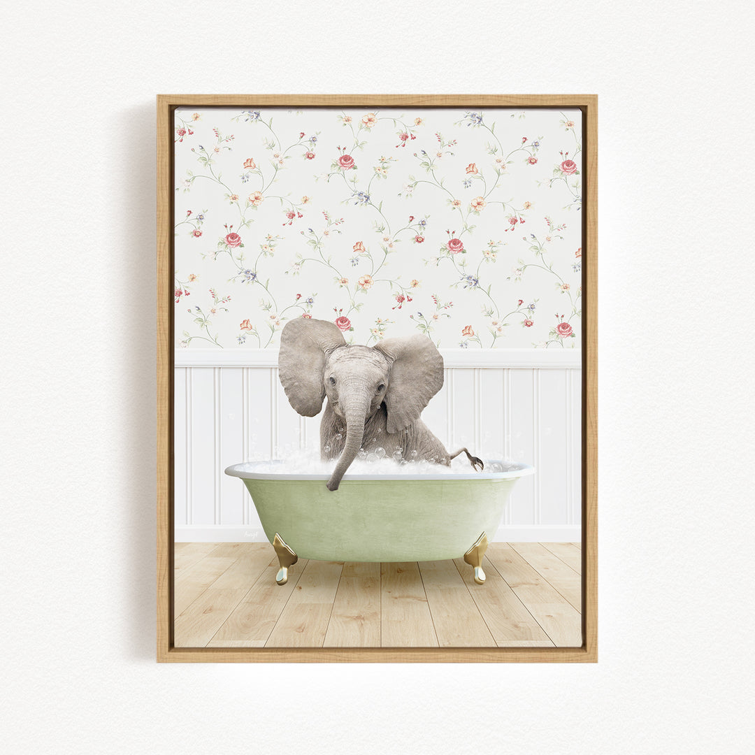 A baby elephant sitting in a green bathtub filled with water, surrounded by a floral wallpaper.