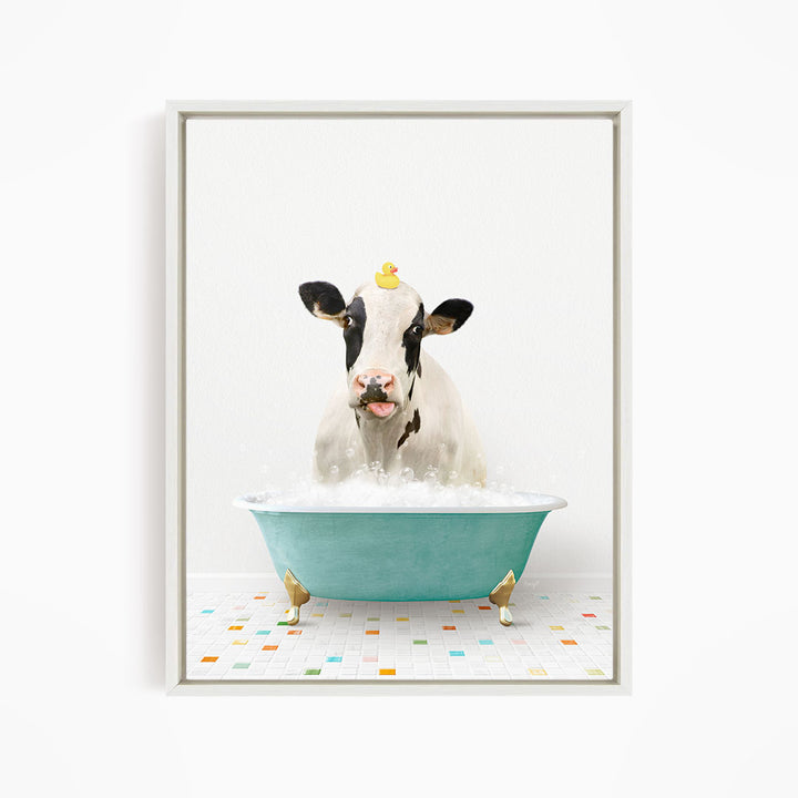 A cow is sitting in a blue bathtub filled with bubbles, with a yellow rubber duck perched on its head.