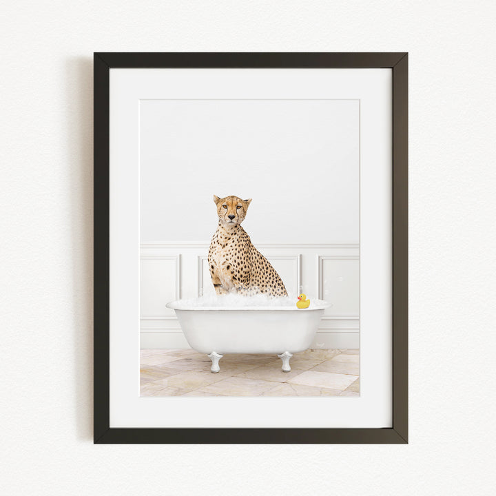 A cheetah sitting in a white bathtub filled with water, with a yellow rubber duck floating in the water.