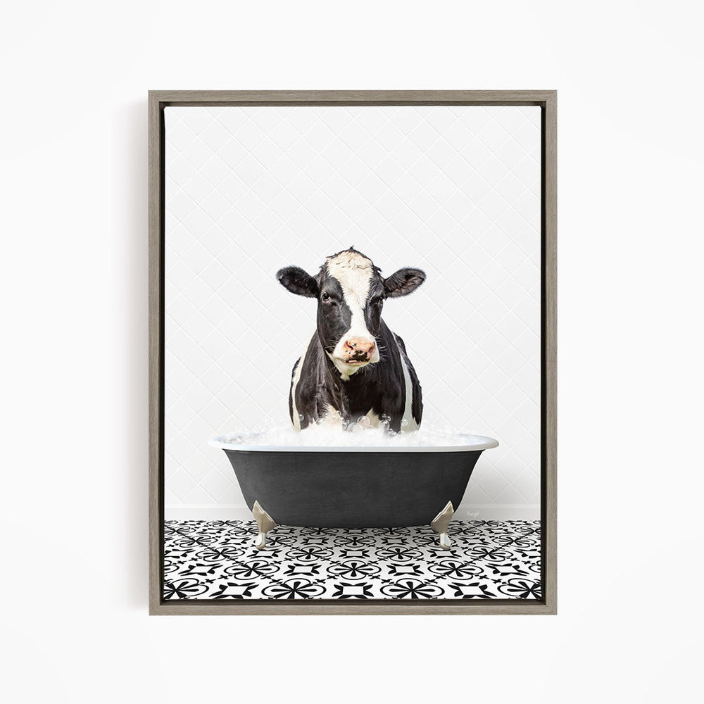 A black and white cow standing in a bathtub filled with water, creating a whimsical and humorous scene.