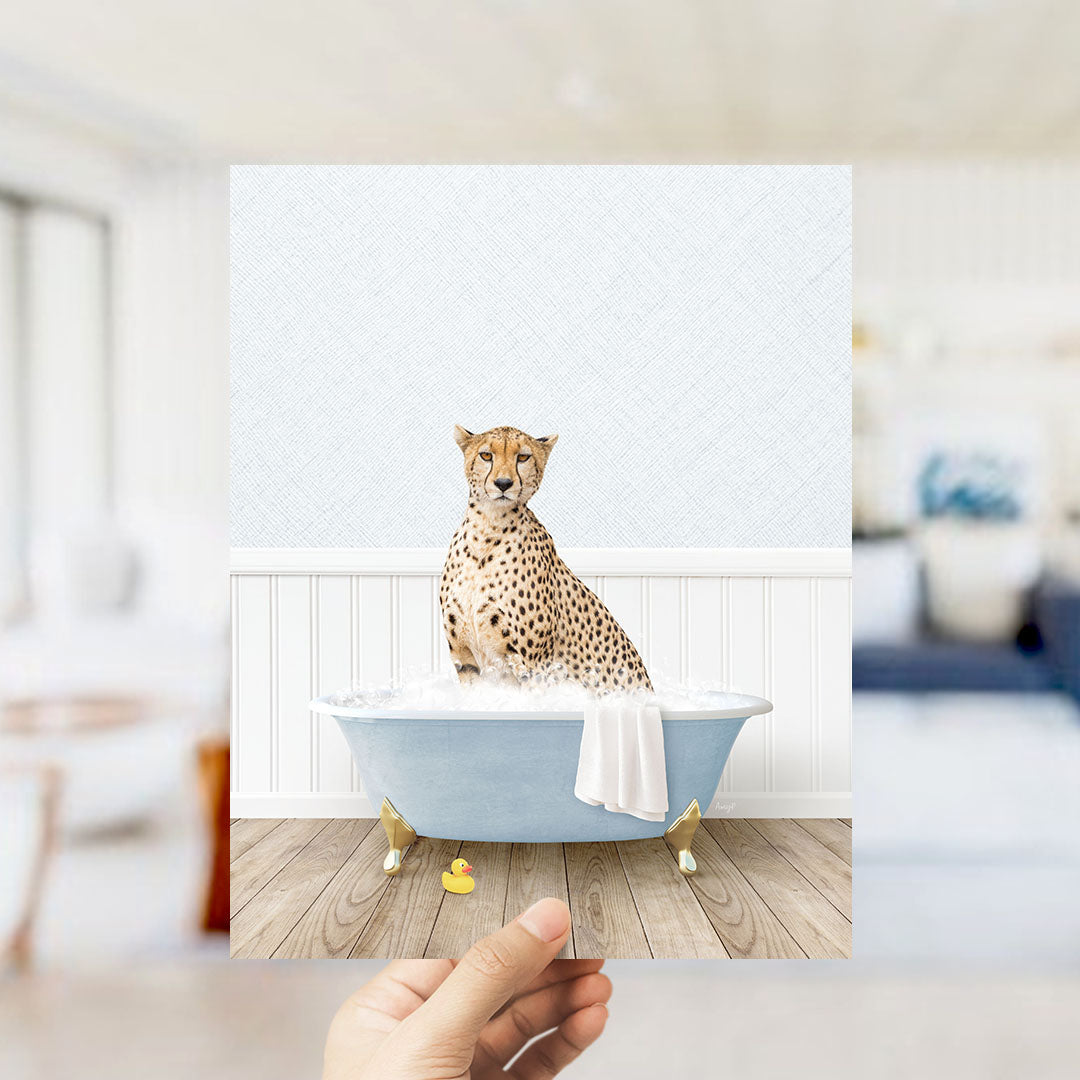 A cheetah sitting in a blue bathtub filled with water, surrounded by a white bathtub, a towel, and a rubber duck.