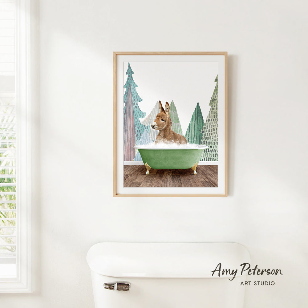 A framed print of a dog sitting in a green bathtub, surrounded by pine trees, is hanging on a white wall.