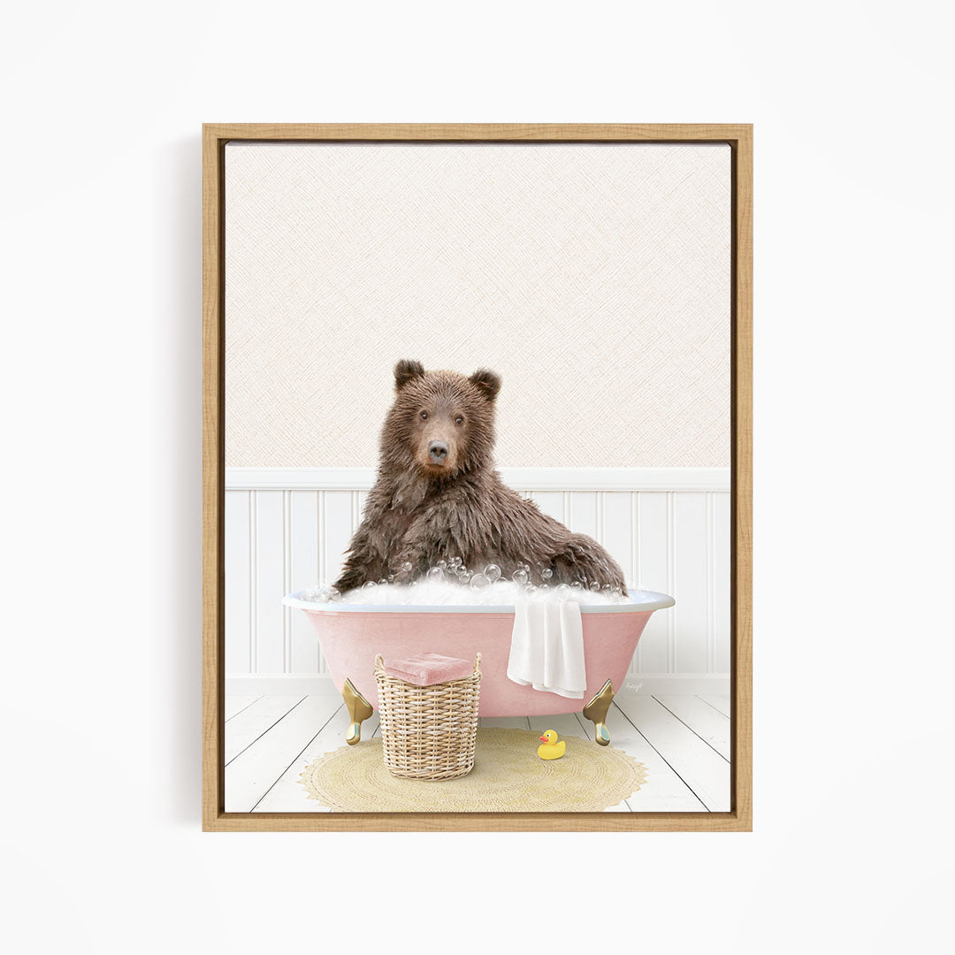 A brown bear sitting in a pink bathtub filled with bubbles, surrounded by rubber ducks and a basket.