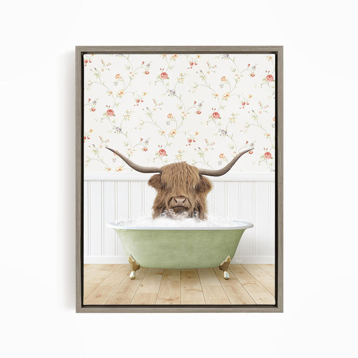 A brown cow with long horns is sitting in a green bathtub filled with water, surrounded by a floral wallpaper.